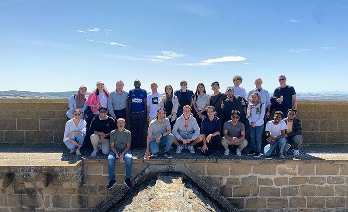 Large group photo on a stone terrace, EMJMD cohort, 2025